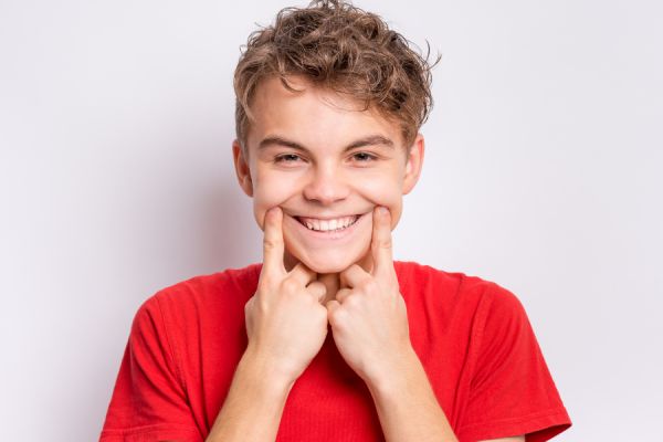 A woman with a cheerful smile, featuring clear braces that enhance her dental aesthetics.